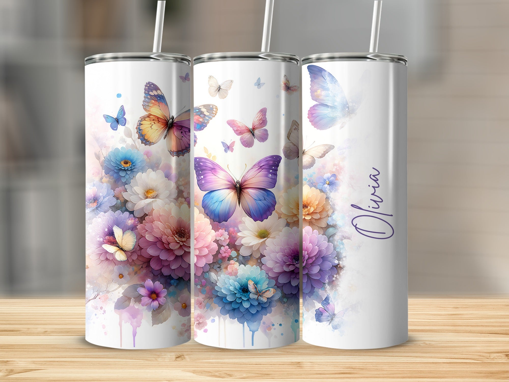 Three tumblers with butterflies and floral designs, one says "Olivia".