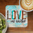 Coaster with "LOVE one another" text and rustic wood, teal, and leopard print design.