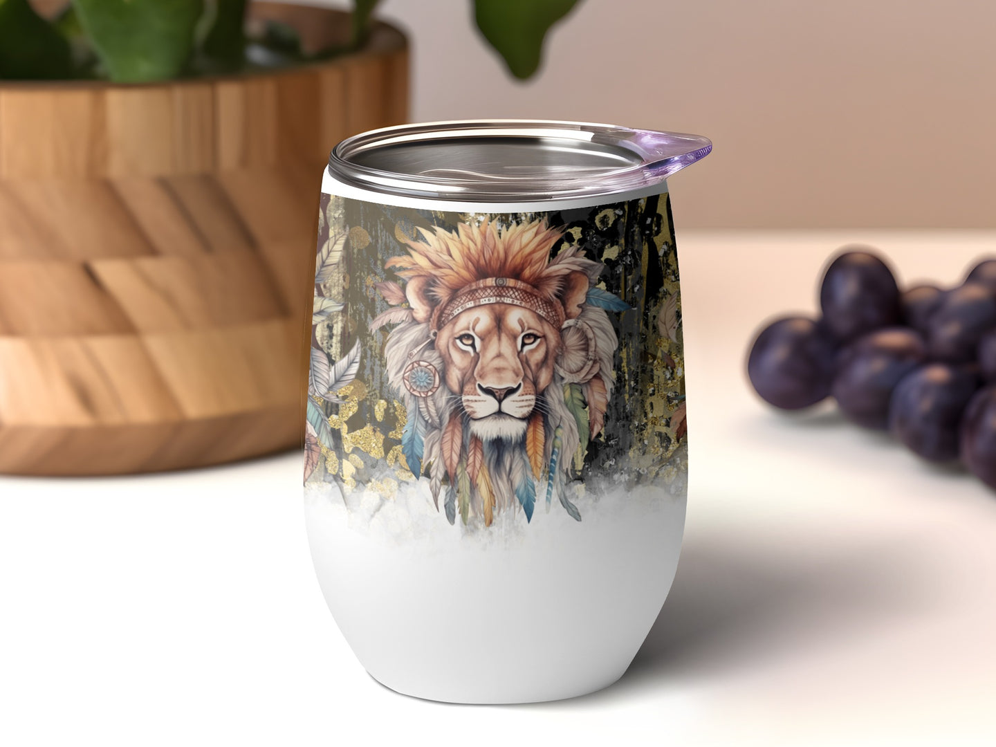 Boho lion with feathers and gold accents on a white insulated tumbler.