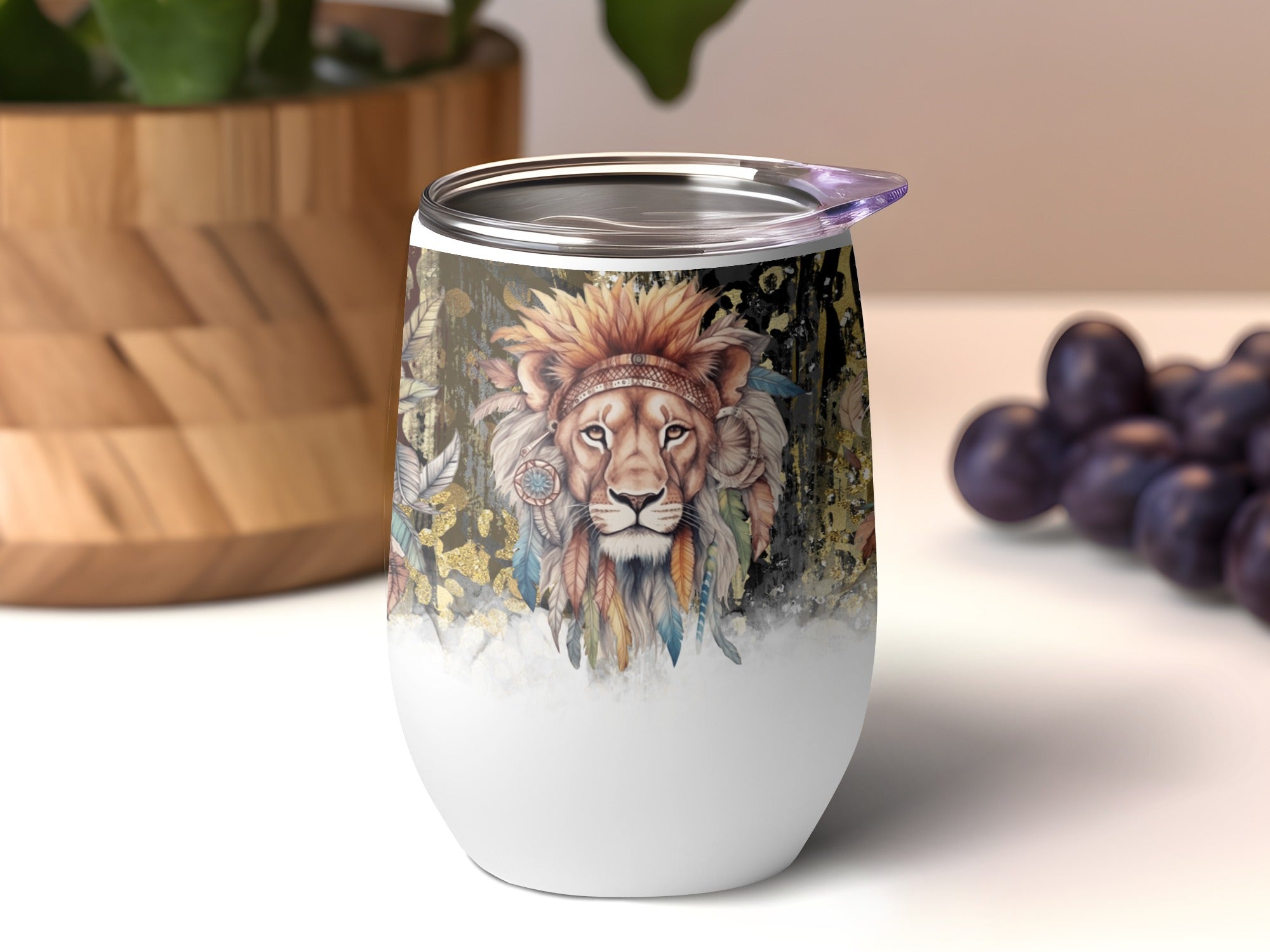 Boho lion with feathers and gold accents on a white insulated tumbler.