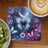 Butterfly and moon art on a coaster next to kiwi and coffee.