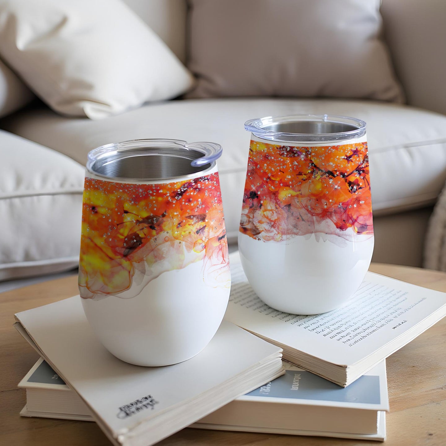 Two white tumblers with abstract orange and yellow watercolor designs.