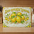 Sun-ripened lemons with flowers and leaves on a vintage-style cutting board.