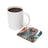 White mug with coffee next to a coaster with a woman and butterflies, "never stop looking up".