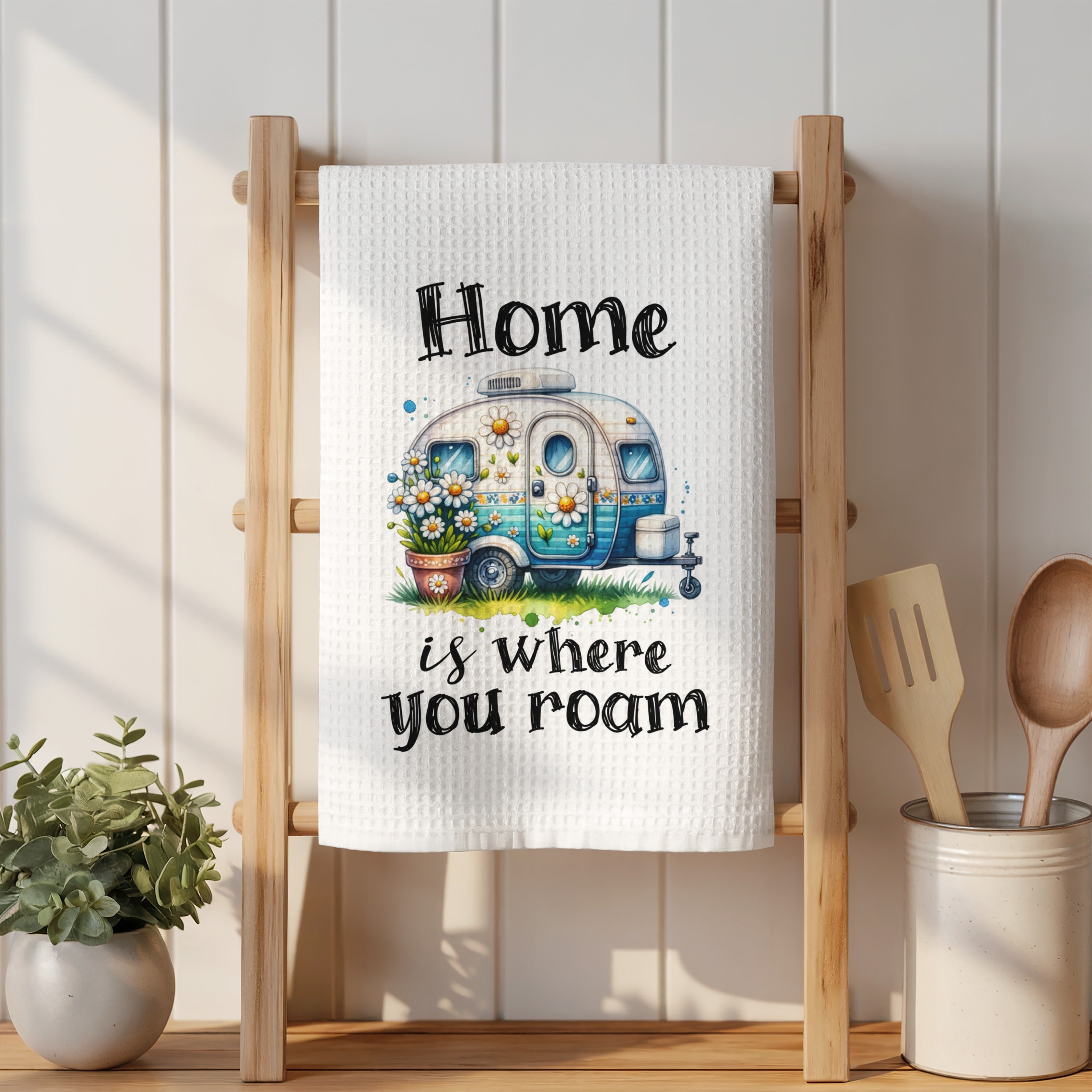 White towel with "Home is where you roam" text and a watercolor camper illustration.