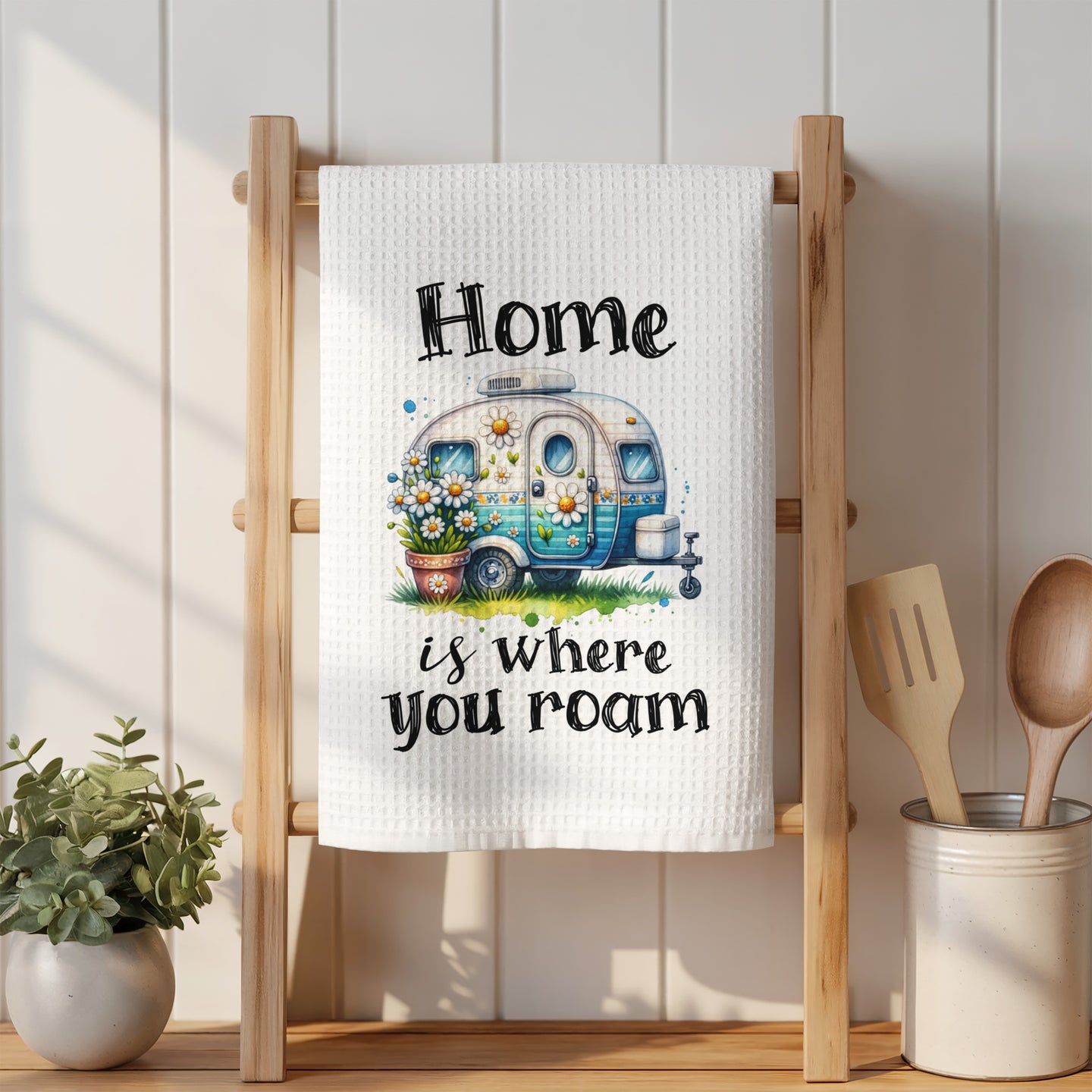 White towel with "Home is where you roam" text and a watercolor camper illustration.