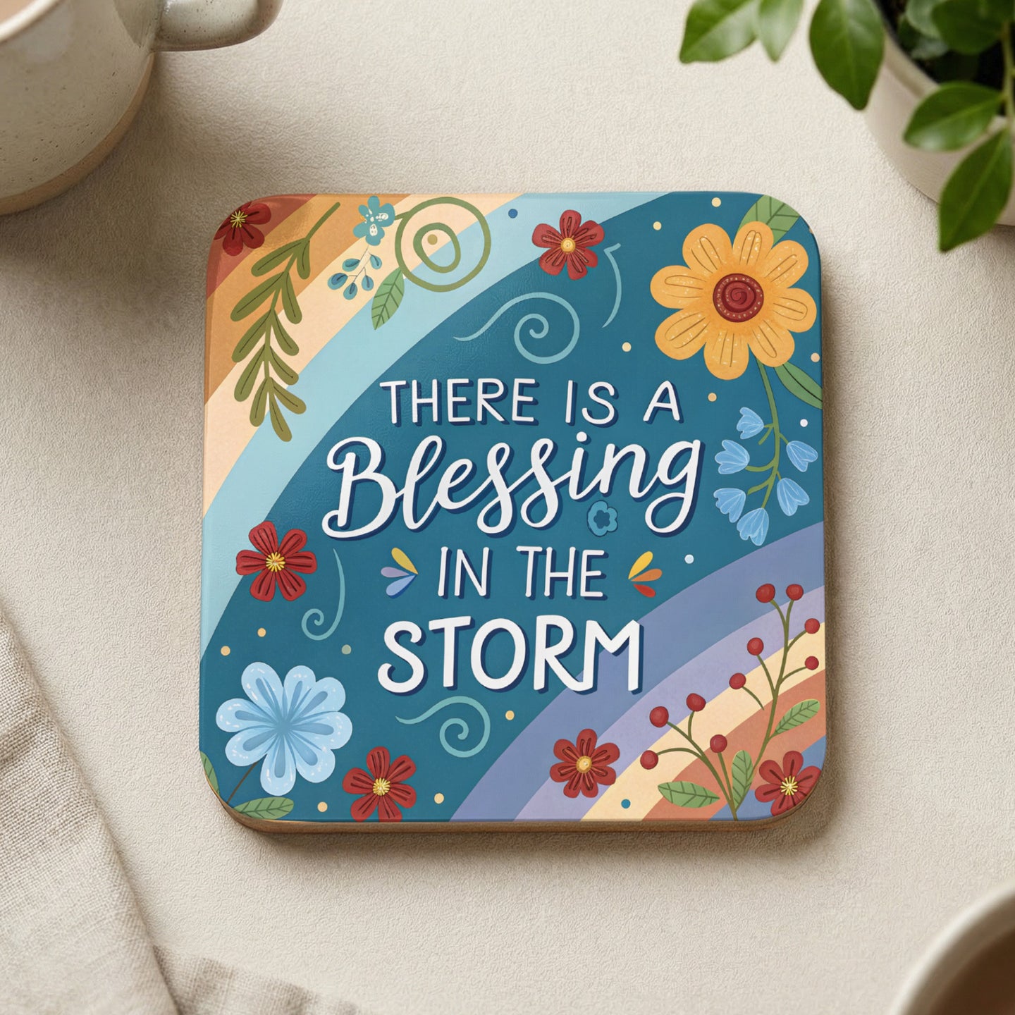 Square coaster with colorful floral design and "There is a blessing in the storm" text.