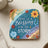 Square coaster with colorful floral design and "There is a blessing in the storm" text.