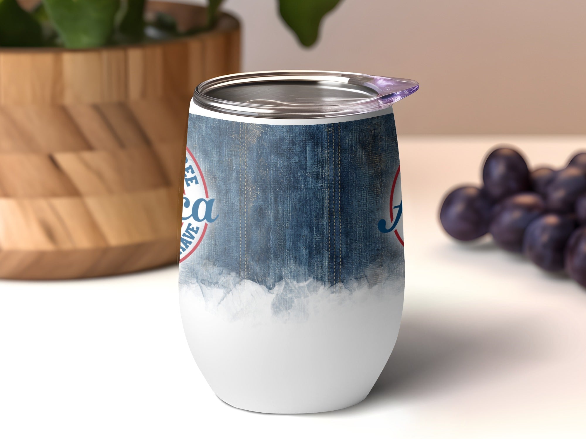 Blue denim pattern stemless wine tumbler with white bottom and blue text.