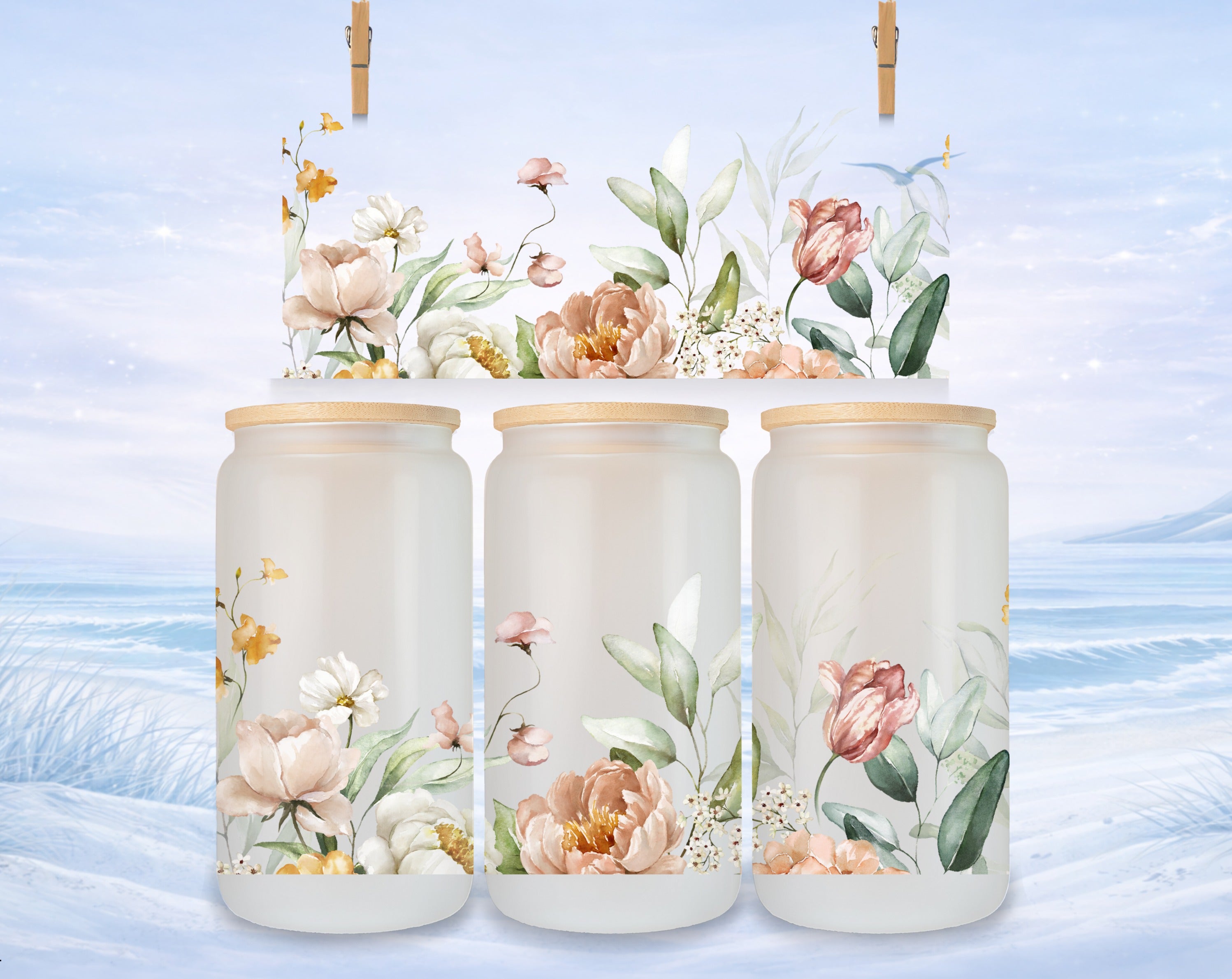 Three frosted glass jars with floral designs, set against a soft winter backdrop.