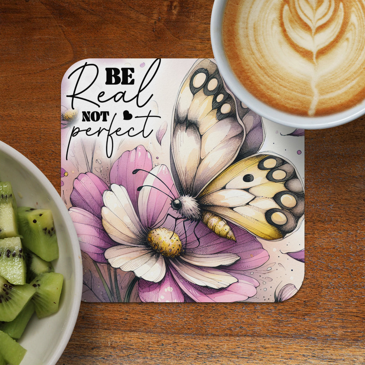 Coaster with butterfly on pink flower, "Be not perfect" text, and coffee.