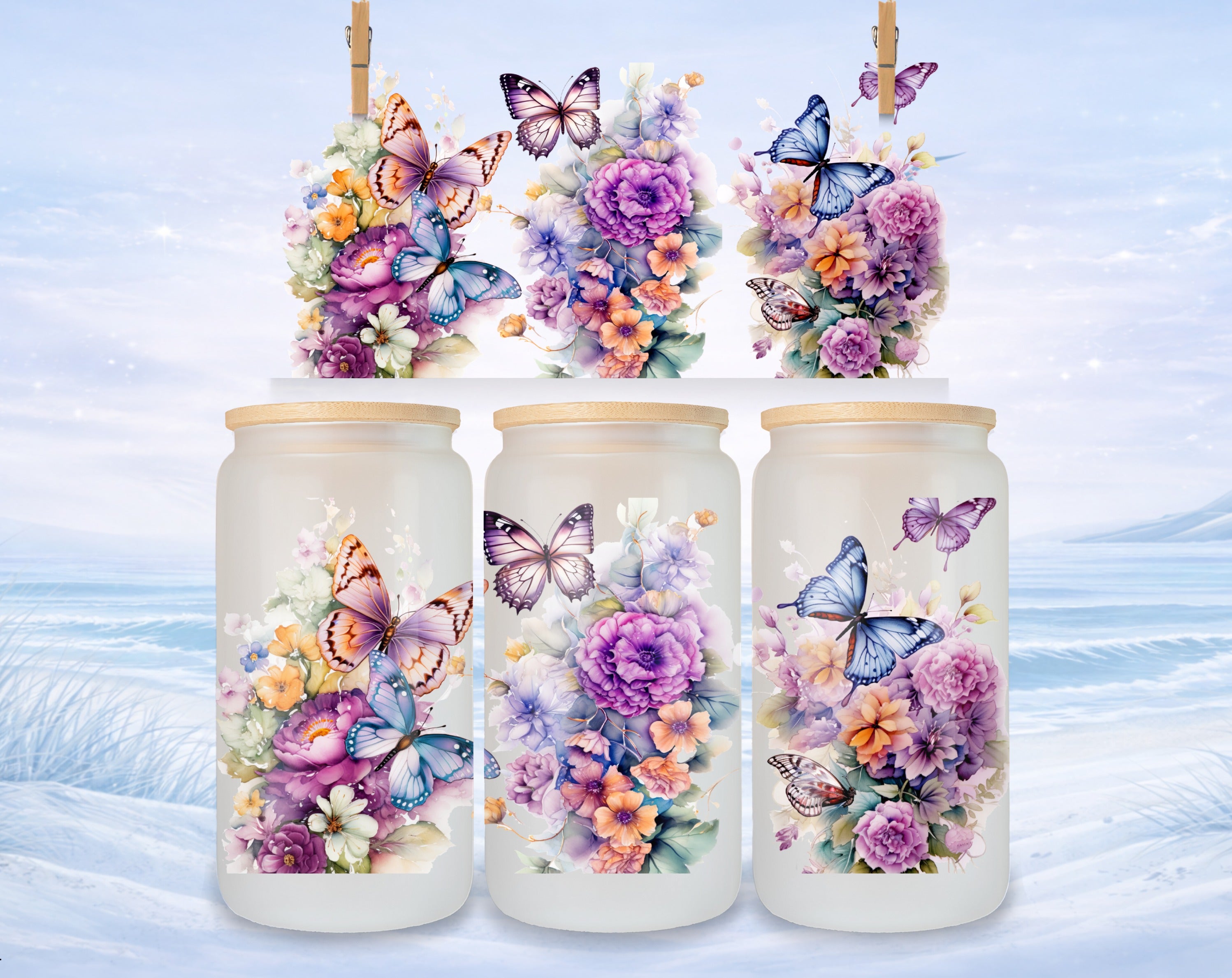 Three frosted glass tumblers with floral and butterfly designs.