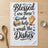 Blessed are those who help wash the dishes graphic on a kitchen towel.