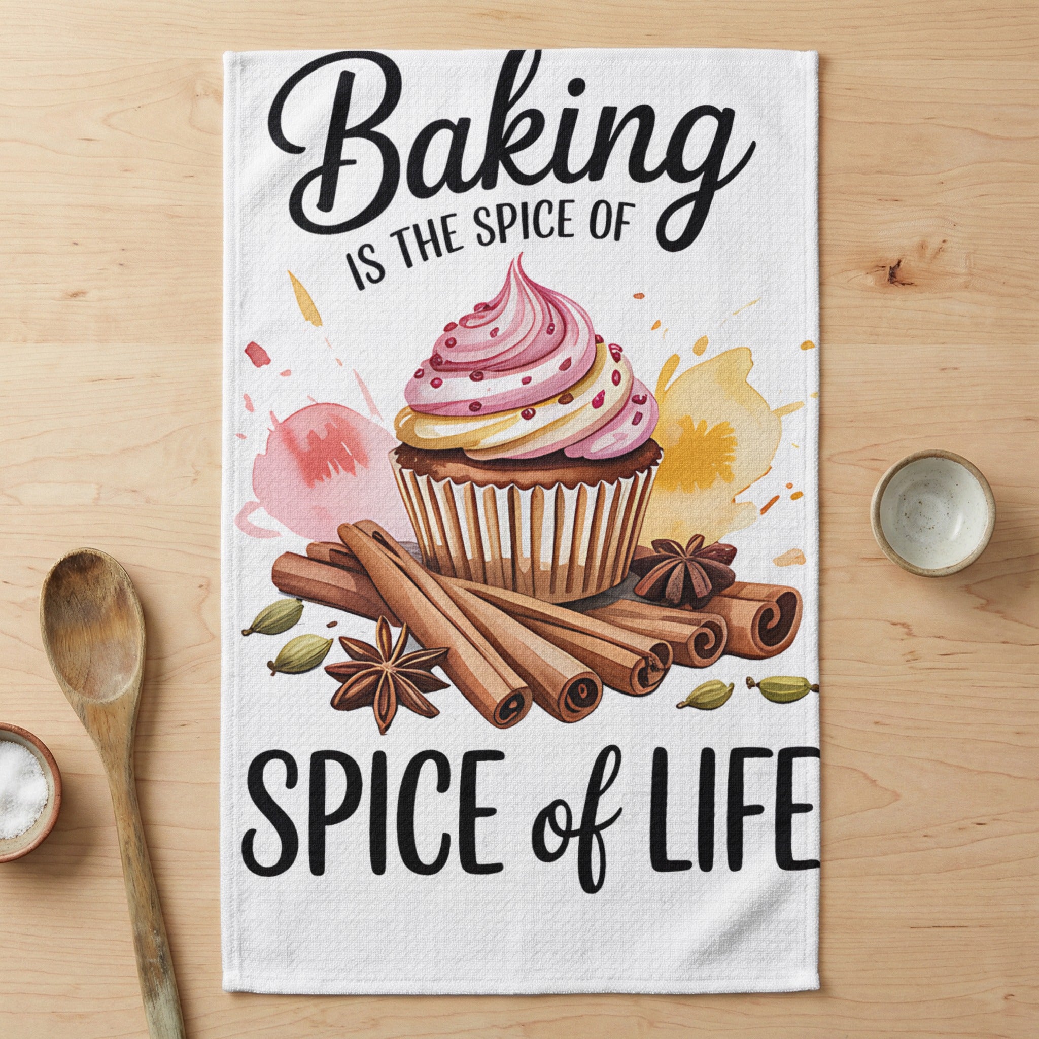 Cupcake with pink frosting, cinnamon sticks, cardamom pods, and text "Baking is the Spice of Life".