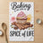 Cupcake with pink frosting, cinnamon sticks, cardamom pods, and text "Baking is the Spice of Life".