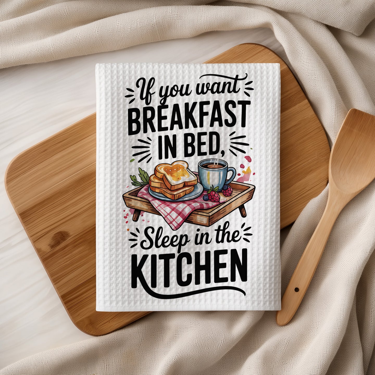 Waffle towel with "If you want breakfast in bed, sleep in the kitchen" text and toast.