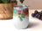 White stemless tumbler with colorful abstract berry design and grape clusters.