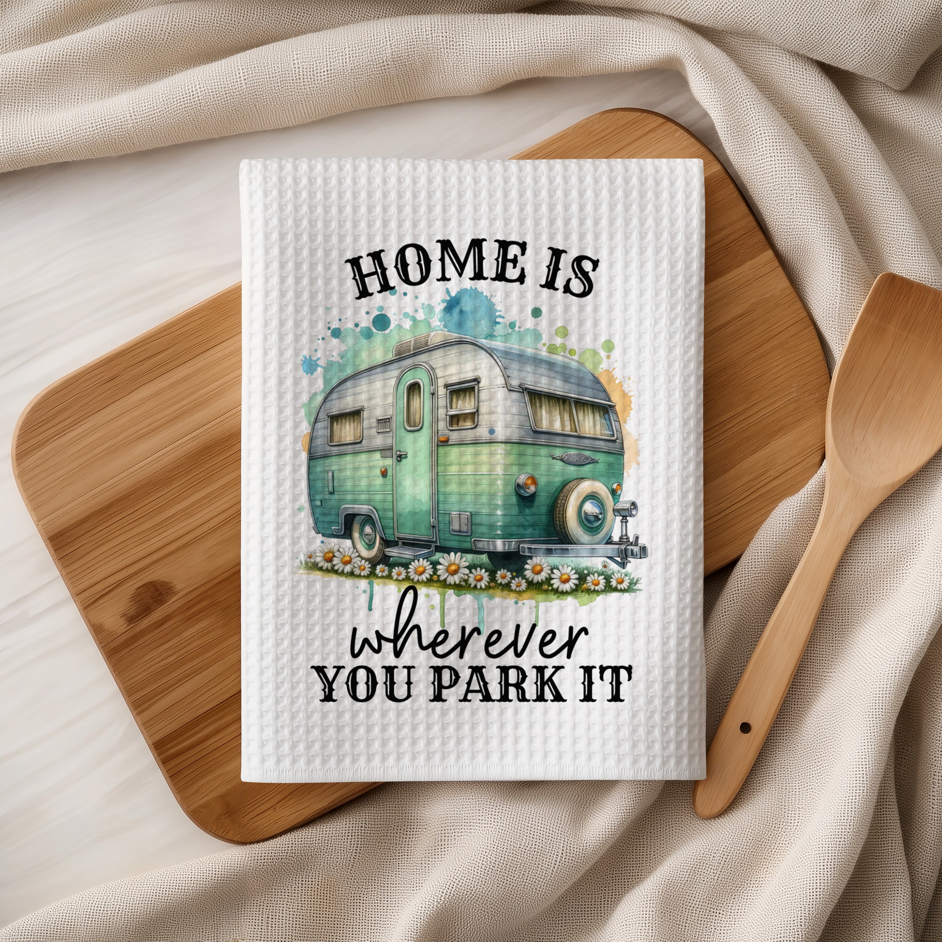 White kitchen towel with "HOME IS WHEREVER YOU PARK IT" and a vintage camper.