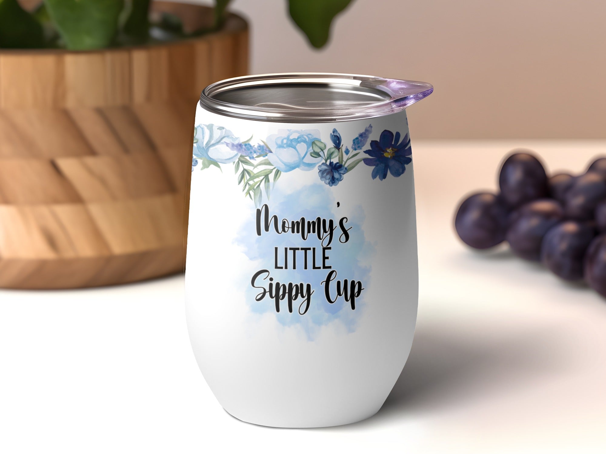 White stemless tumbler with blue floral accents and "Mommy's Little Sippy Cup" text.