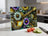 Glass cutting board with floral and guitar design, sliced tomatoes, and cucumber.