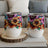 Two white stemless wine tumblers featuring a colorful sunflower floral design.