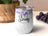 White tumbler with floral accents and "She is Strong" text.