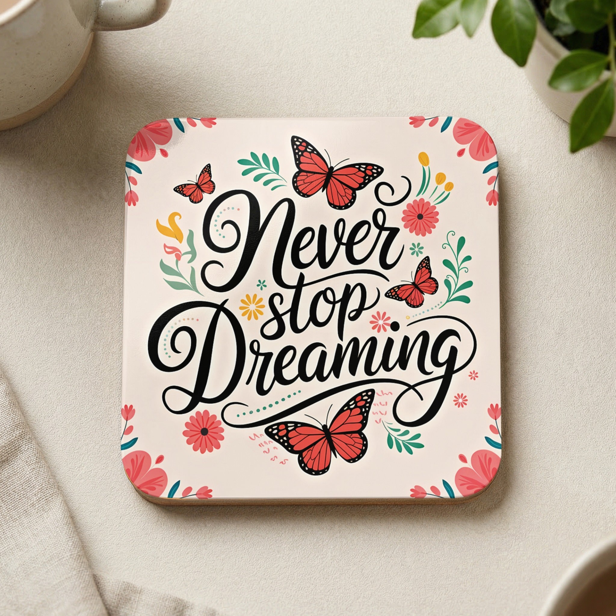 Coaster with "Never stop Dreaming" text, butterflies, and floral accents.