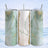 Mint green marbled tumbler with "Emma" in gold script on a glitter background.