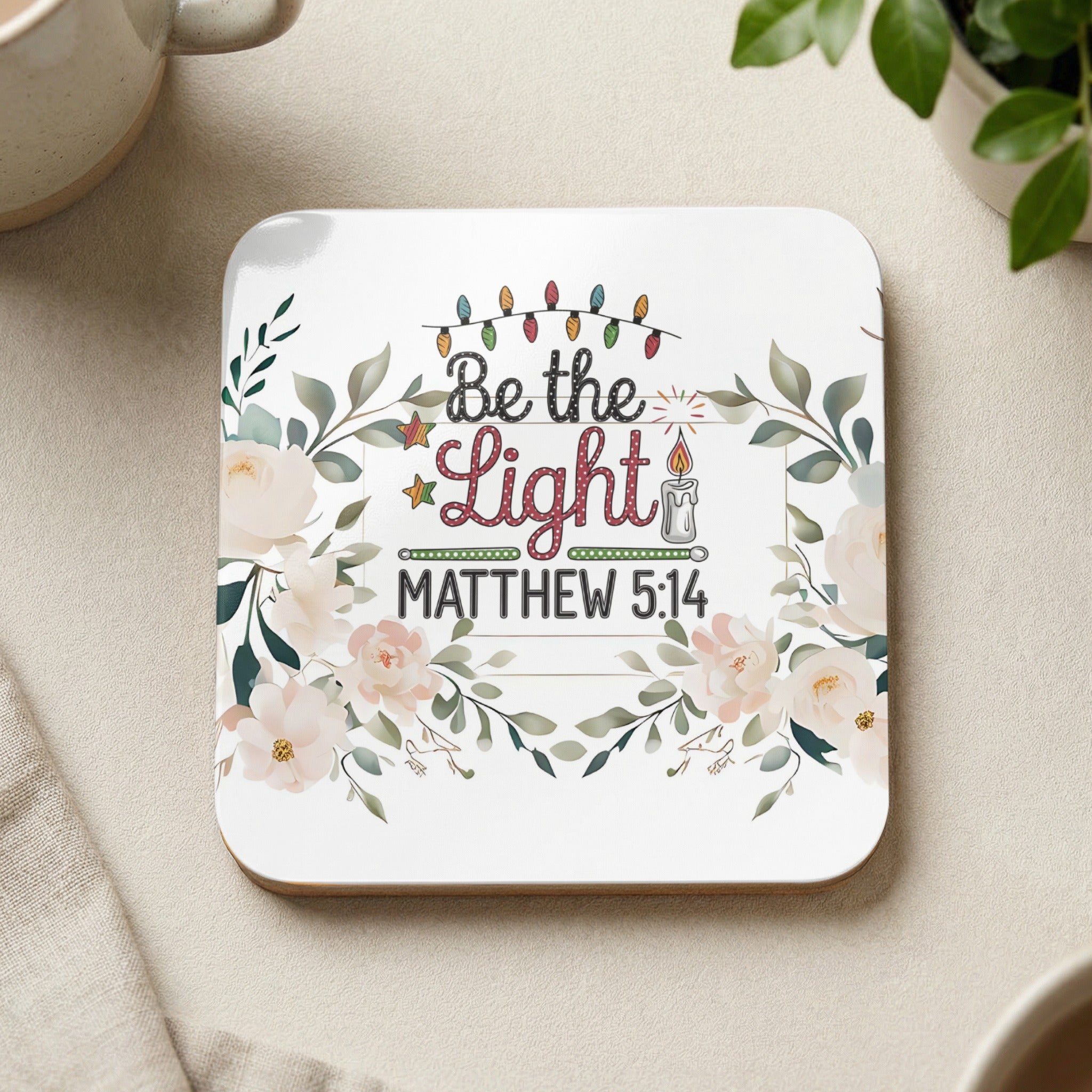 Square coaster with floral design, Christmas lights, and "Be the Light Matthew 5:14" text.