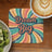 "Dream Big" text on a retro coaster next to kiwi slices and coffee.