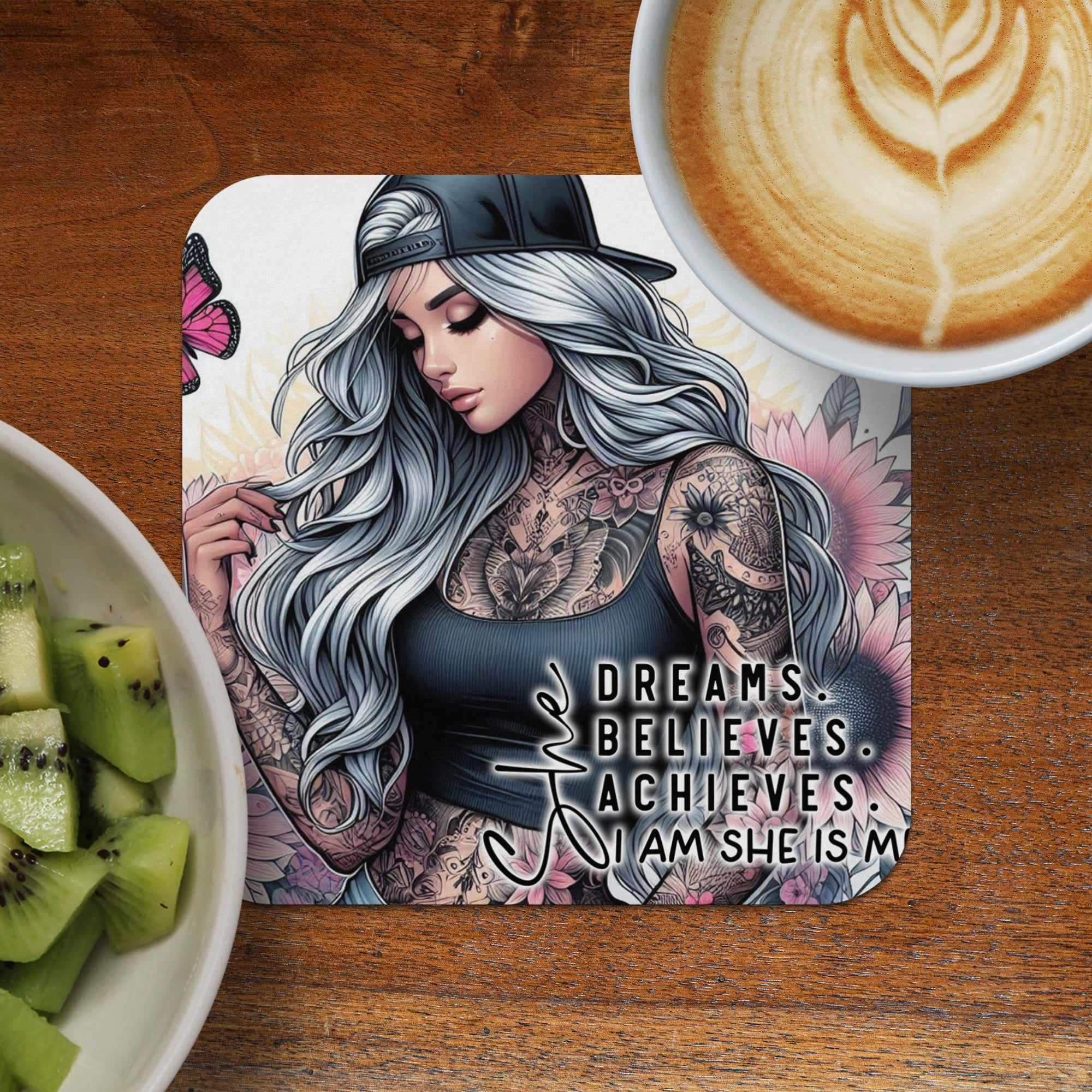Woman with tattoos, a butterfly, and motivational text on a coaster.