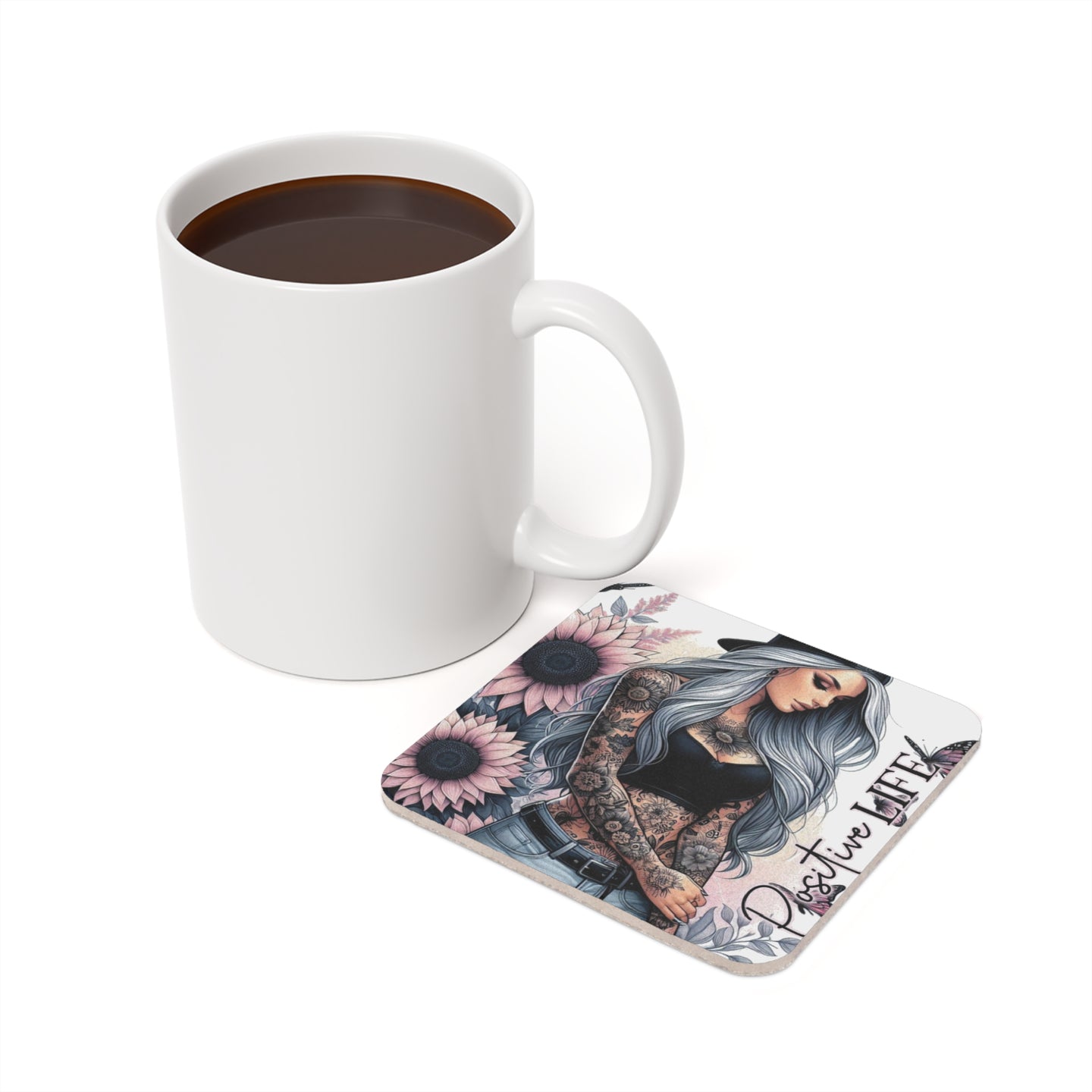 Woman with tattoos and sunflowers on coaster next to coffee mug.