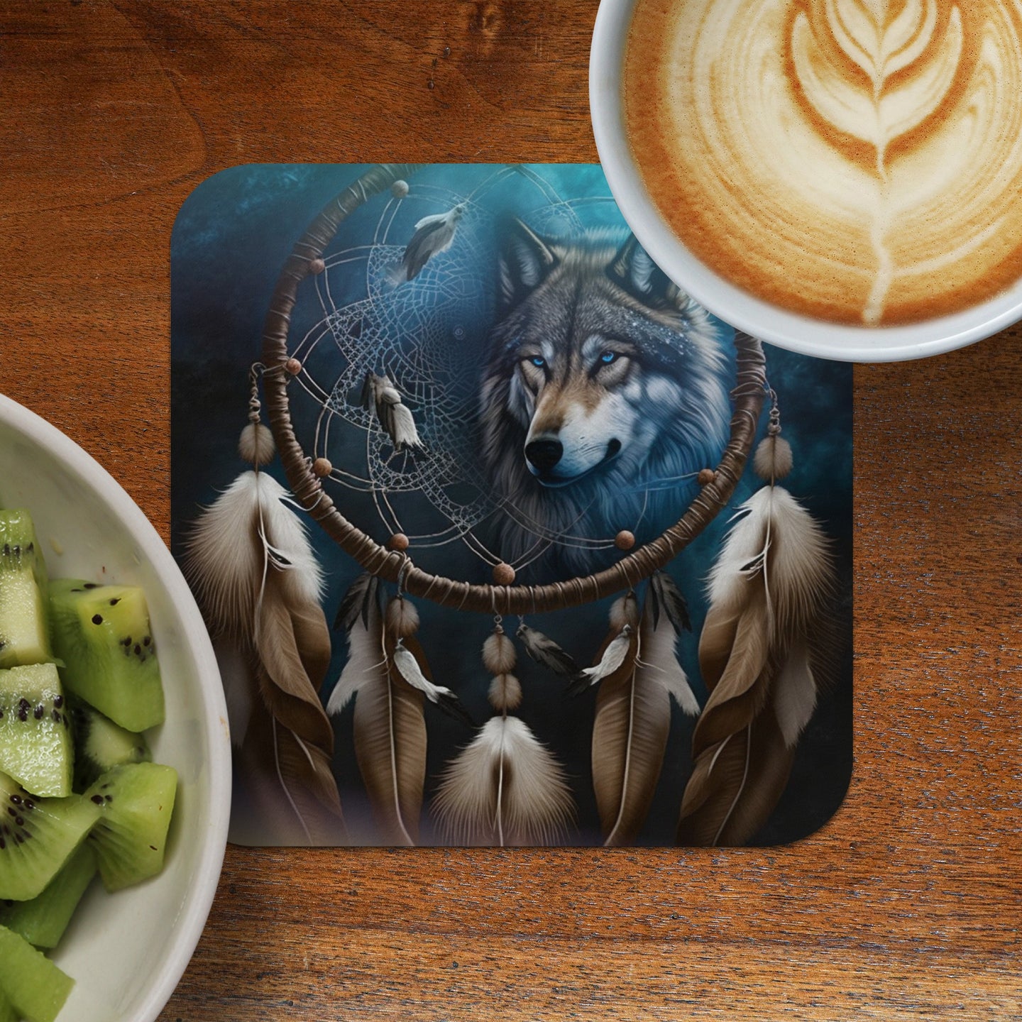 Wolf dreamcatcher with feathers, coffee, and kiwi fruit on wooden table.