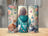 Three tumblers with floral and butterfly designs featuring a "Cat Mom" graphic.