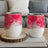 Two white wine tumblers with pink watercolor design on a wooden coaster.