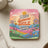 Coaster with "Make Someone Smile Today" text and colorful retro floral landscape.
