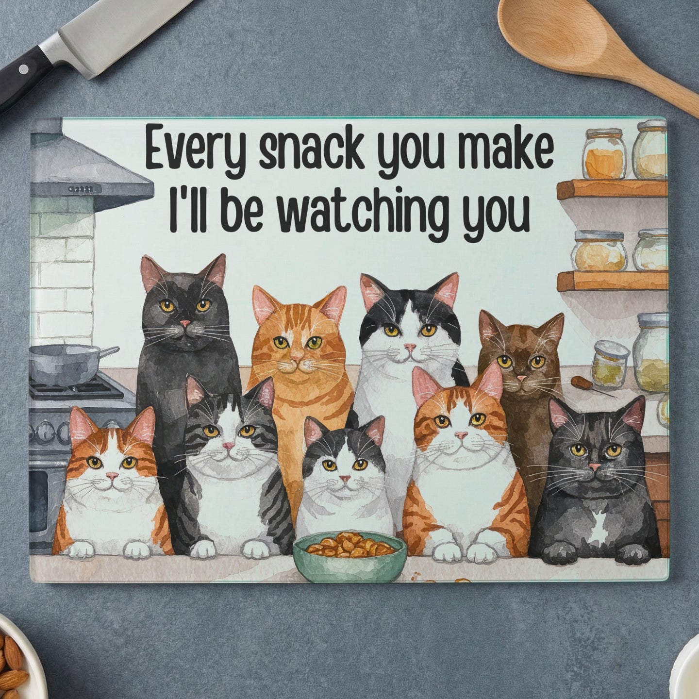 Ten cats watch a bowl of food under the text "Every snack you make I'll be watching you".