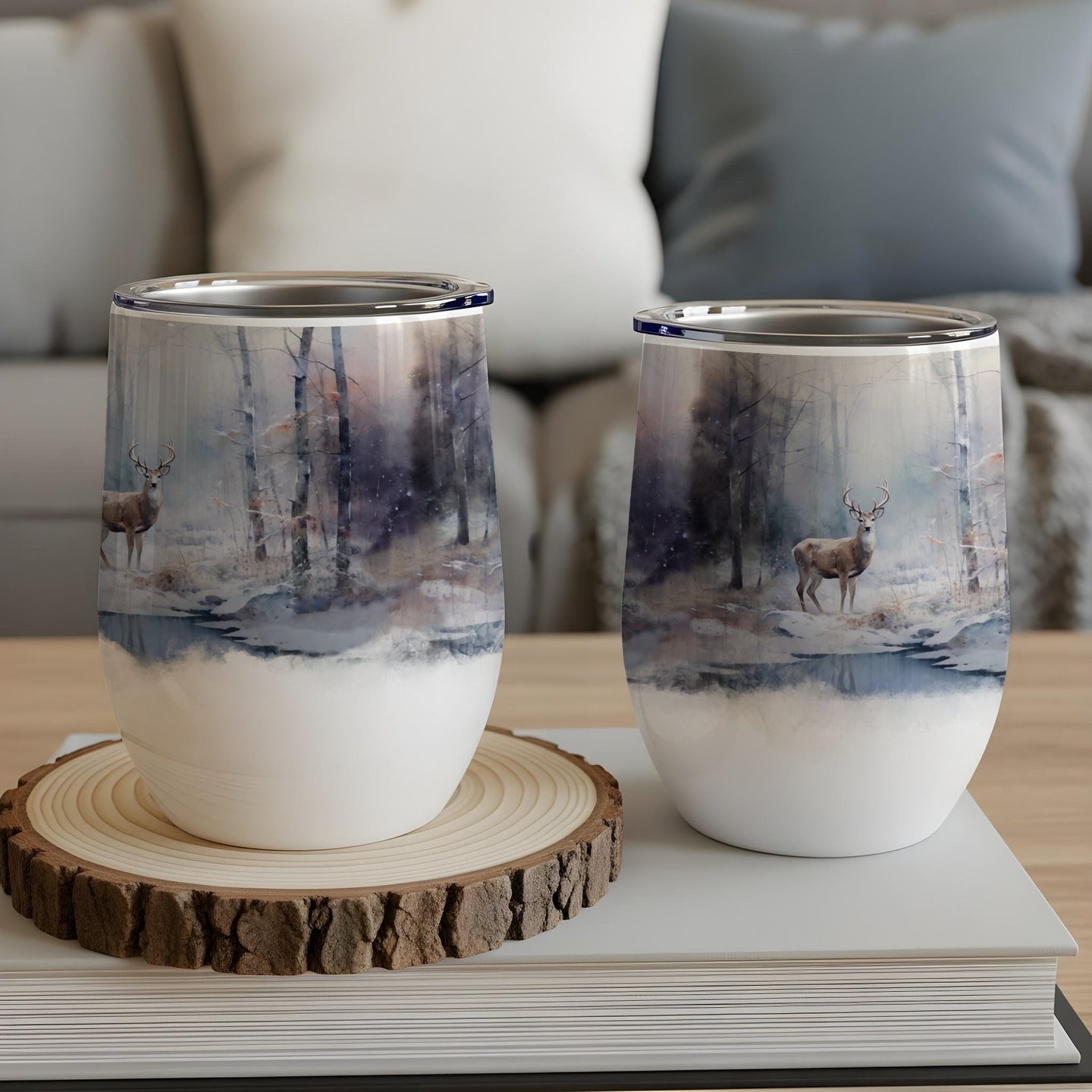 Two deer in a snowy forest scene on insulated wine tumblers.