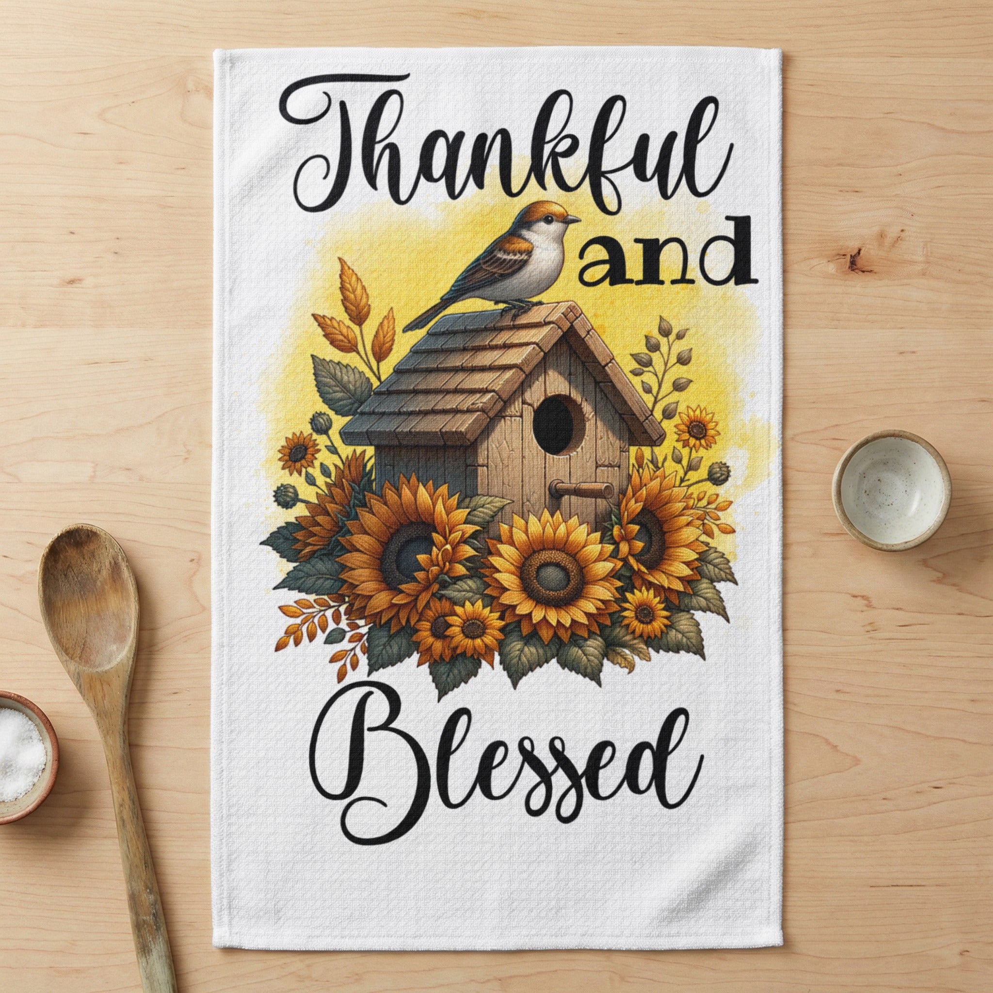 Birdhouse with sunflowers and text "Thankful and Blessed" on a tea towel.