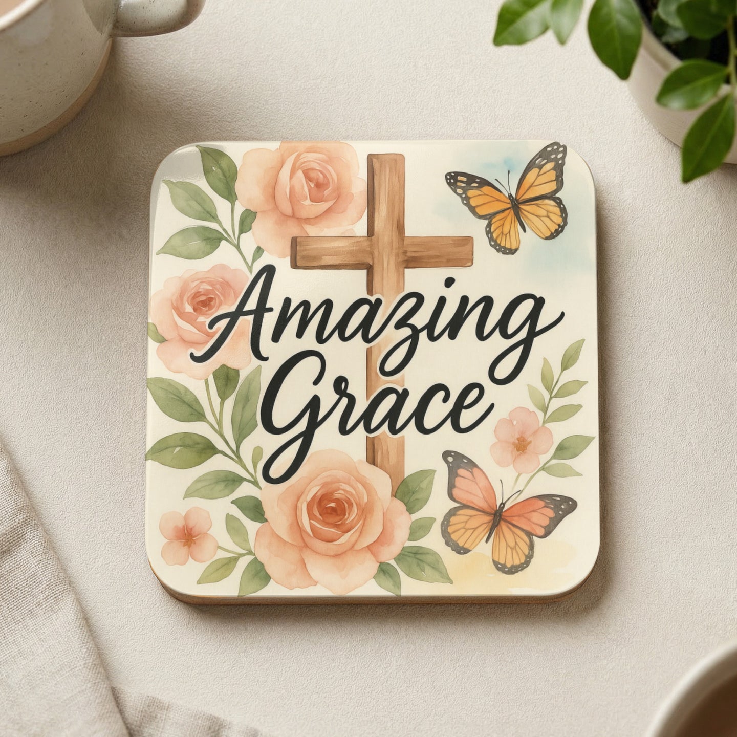 Square coaster with a wooden cross, pink roses, and two butterflies.