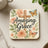 Square coaster with a wooden cross, pink roses, and two butterflies.