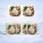 Two mugs with "Happy Birthday" design and floral wreath, set against a snowy background.