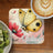 Yellow butterfly on floral design with "Challenge Yourself" text, next to kiwi and coffee.