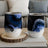 Two abstract art tumblers with blue and black marble design on a wooden coaster.
