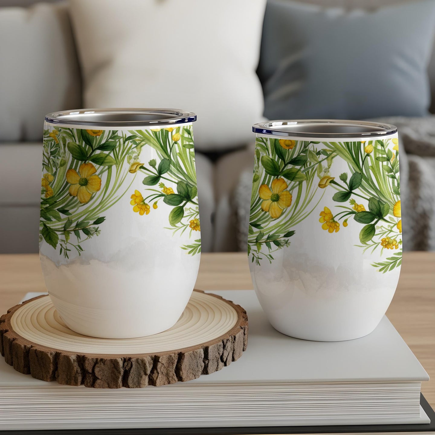 Two insulated tumblers with yellow floral and green leaf pattern.