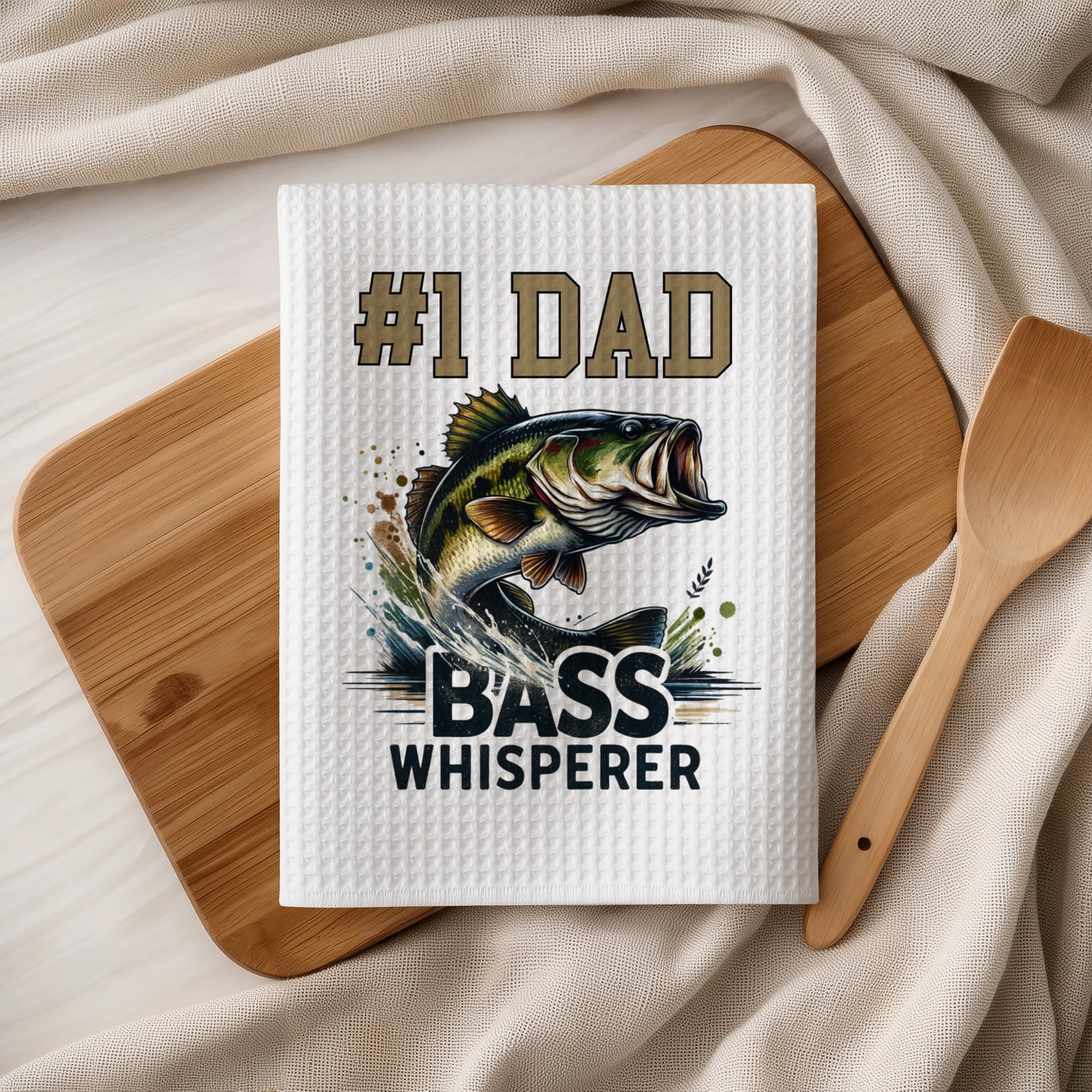 Tea towel with "#1 Dad Bass Whisperer" text and a jumping bass fish graphic.