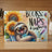Smiling sloth hugging a book with sunflowers and text "Books, Naps & Sunflowers".
