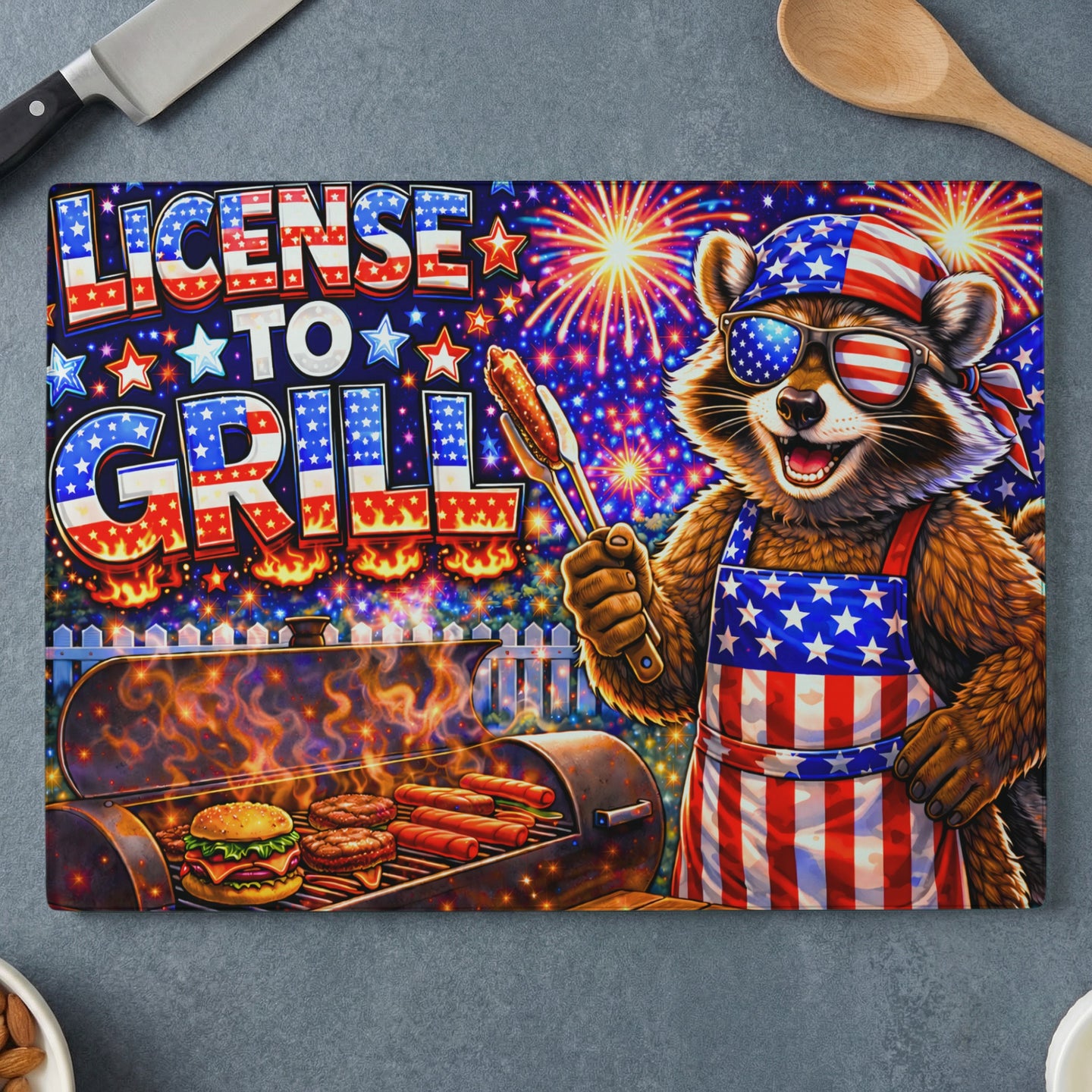 Raccoon in sunglasses and apron holding tongs at grill, "License to Grill" text.