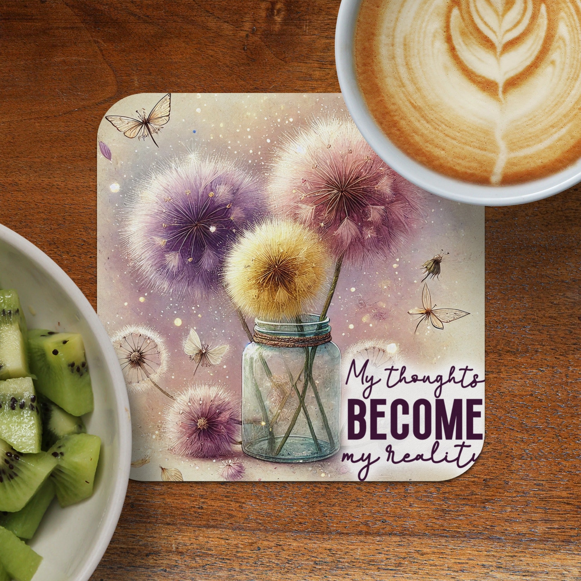 Jar of dandelions with butterflies and text, beside coffee and kiwi.