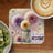 Jar of dandelions with butterflies and text, beside coffee and kiwi.
